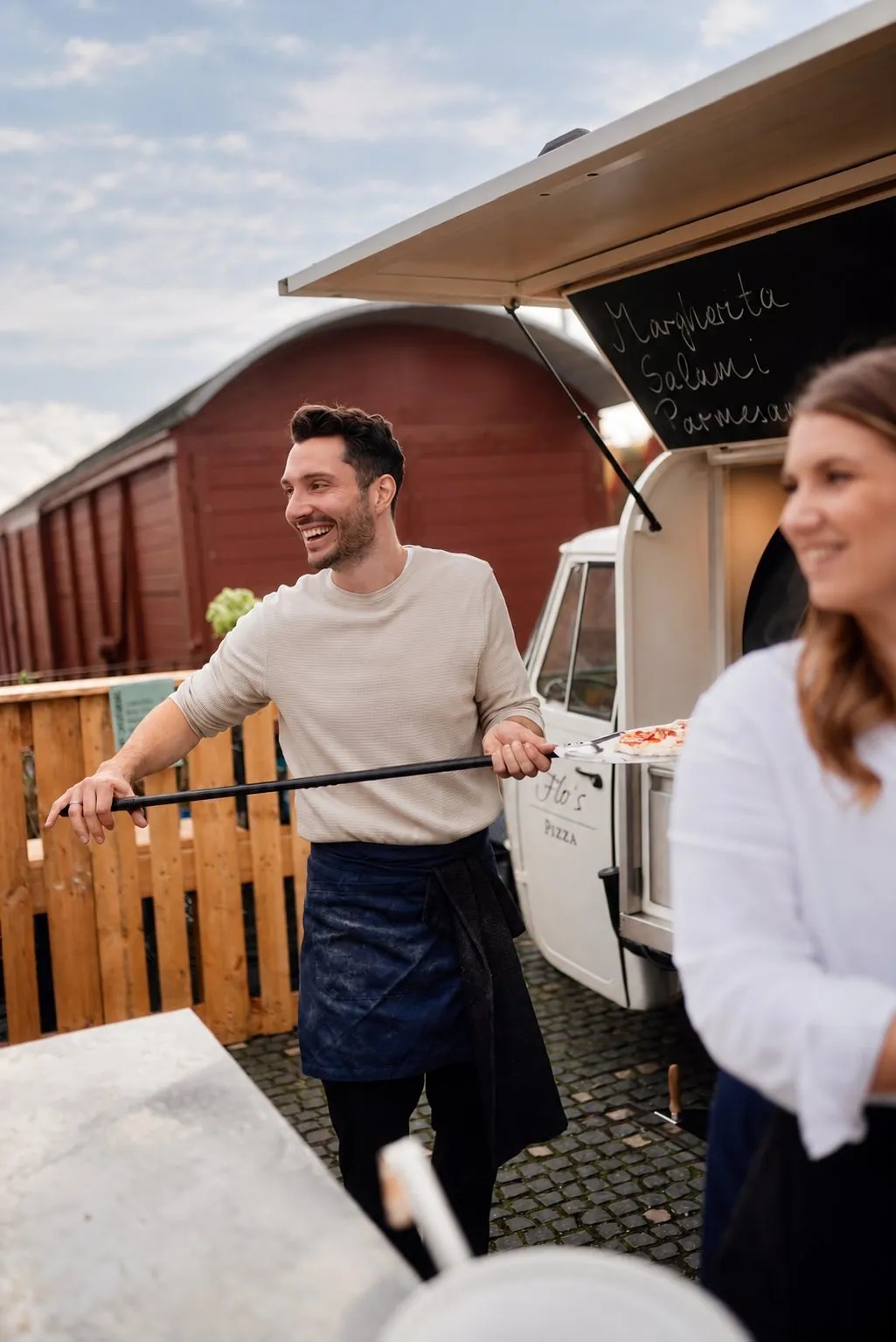 Lachender Pizzabäcker am Foodtruck